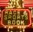 Bright neon lights on a marquee sign display the words 'RACE & SPORTS BOOK'. The sign is surrounded by rows of yellow and white lights against a red background, evoking a vibrant, energetic atmosphere typically associated with casinos or entertainment venues.